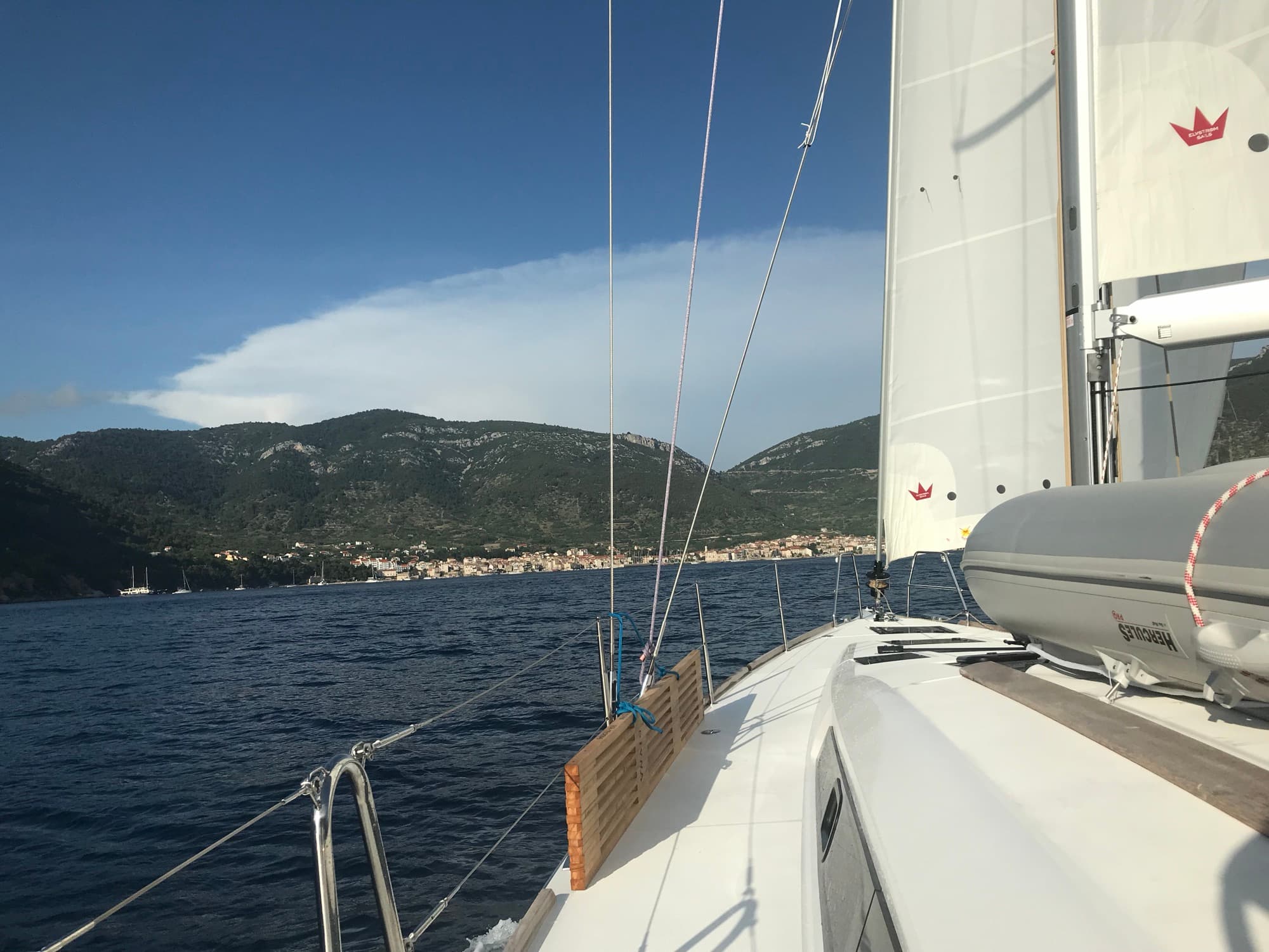 Bavaria 41 sailing toward a coastal mountain range