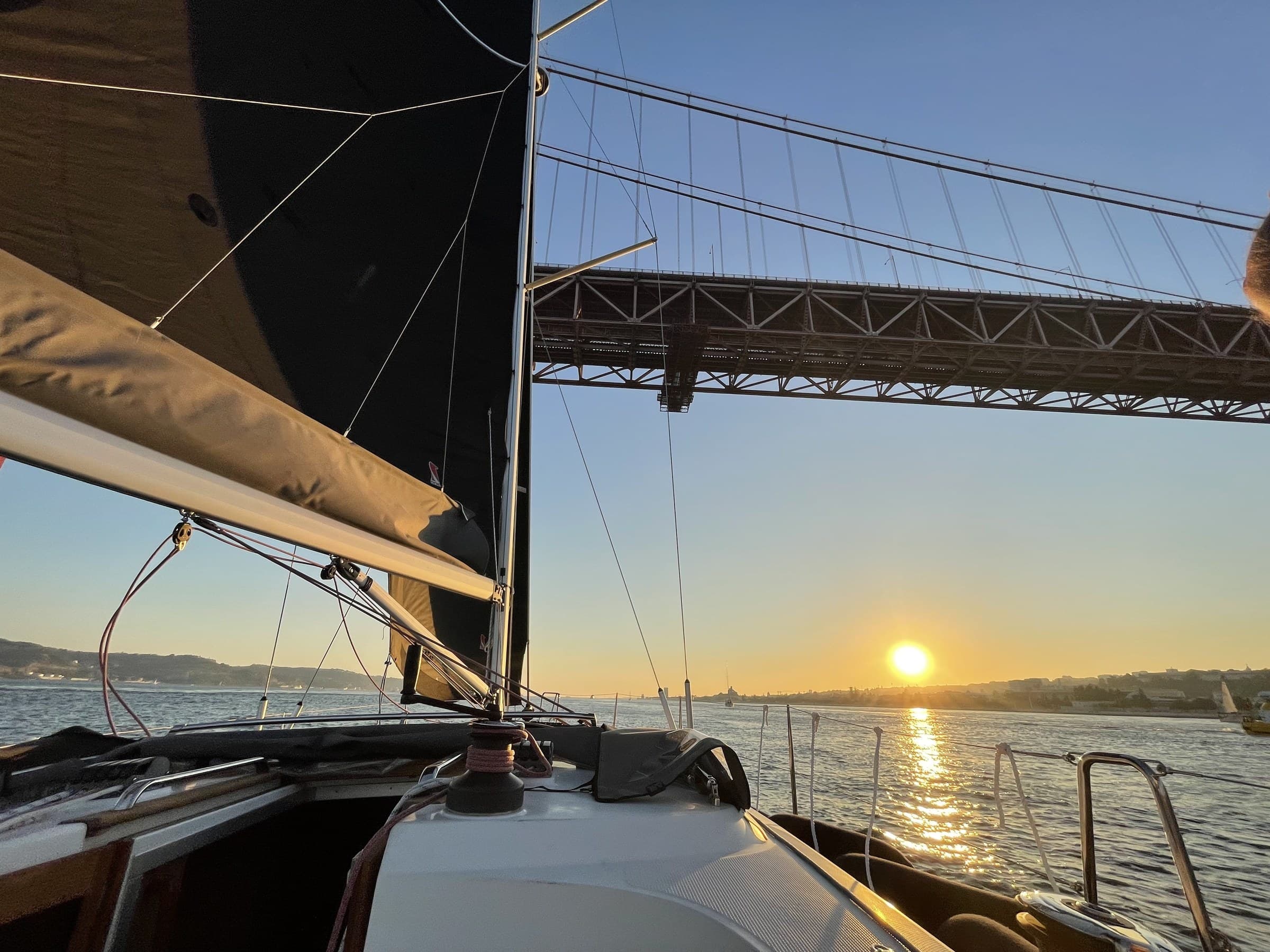 The 25 de Abril bridge at sunset, seen from the deck